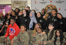 A group photo of Lincoln-West School of Science and Health JROTC cadets and students gathered together at the Cleveland Browns Veterans Day Salute to Service event. The front rows feature several students wearing military camouflage uniforms with JROTC in