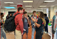 A group of high school students talk with a representative during the Campaign Information Fair at Shaker Heights High School.