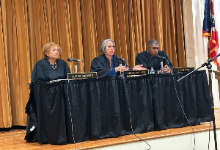 Three judges in black robes sit at a panel table with name plates reading Judge Groves, Judge Forbes, and Judge Ryan, speaking to students at Shaker Heights High School as part of the Eighth District Court of Appeals Courtroom to Classrooms program.