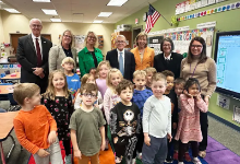 Governor with students in group photo.