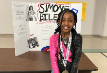 Bedford Student in front of project board