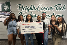 Seven of the Ten teacher academy students holding the oversized $500 check.