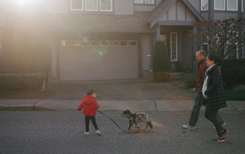 Two parents with boy walking dog