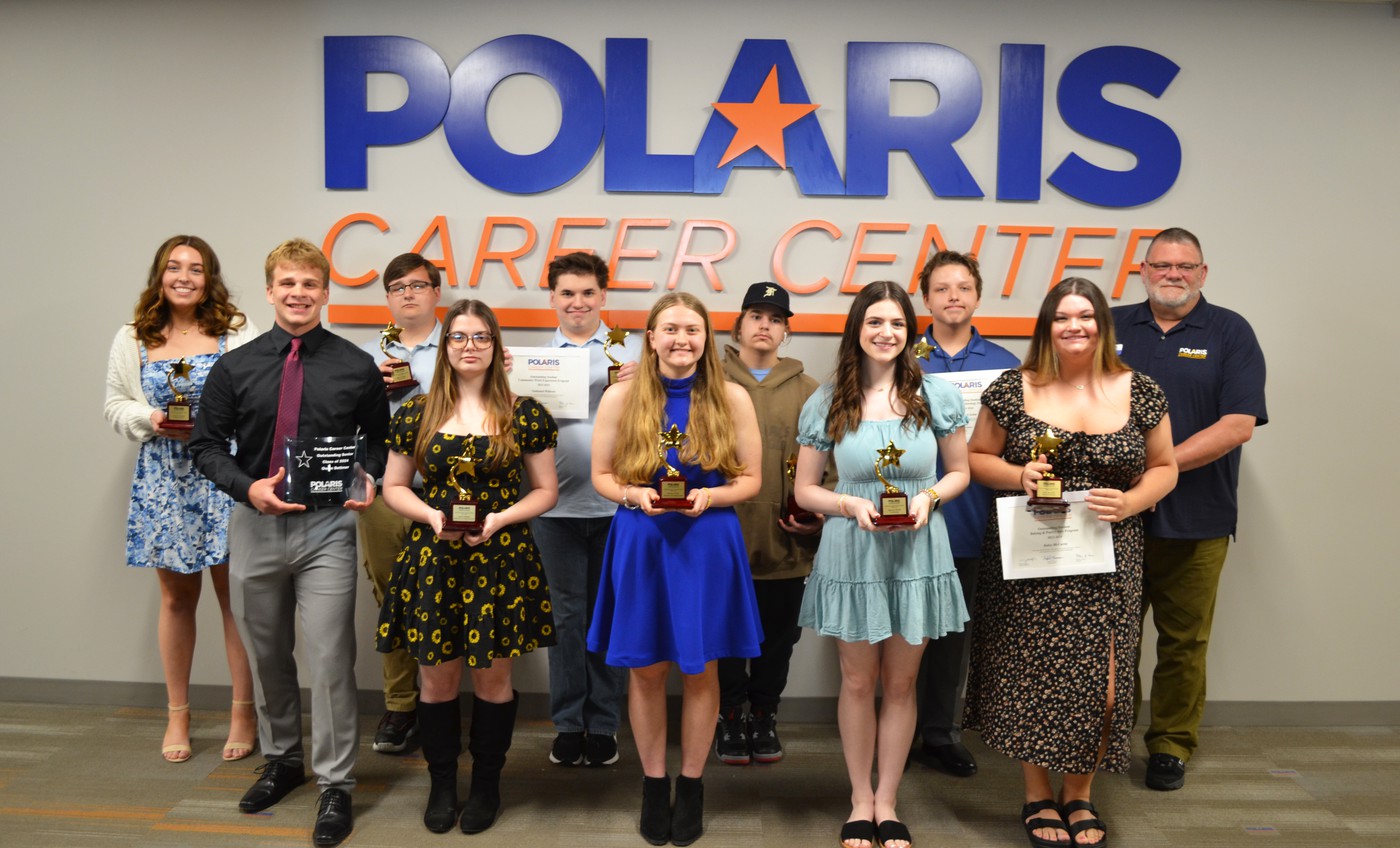 The image shows a group of 10 students, 7 young women and 3 young men, posing in front of a wall with the "Polaris Career Center" logo. The students are dressed nicely and each is holding a certificate and small trophy, indicating they have been recognized for outstanding achievement in their respective career-technical education programs at Berea-Midpark High School.